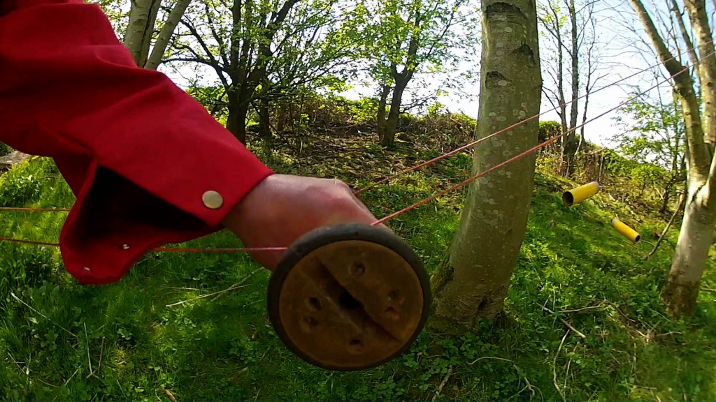 bobbin on pair of string rails in hand